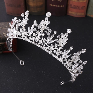 Detailaufnahme einer silbernen Brautkrone mit Kristallen auf dunklem Vintage-Hintergrund