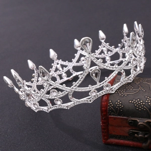 Macro detail of luxury silver bridal crown with teardrop crystals and vintage wood box