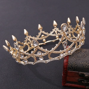 Detail of vintage gold bridal crown with white crystals on an antique wooden box