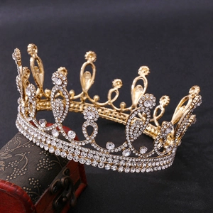 Elegant gold bridal crown with crystal rhinestones for weddings on a vintage wooden box