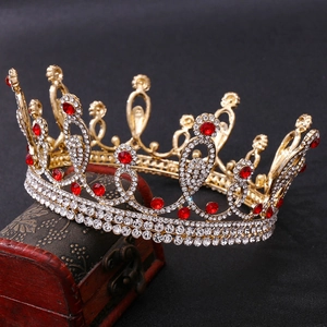 Detail of a vintage golden bridal crown featuring red gemstones and white rhinestones