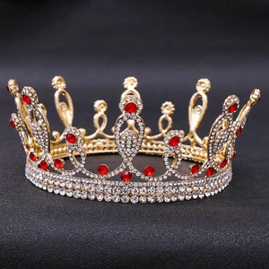 Close-up of golden bridal tiara featuring red rhinestones and polished alloy details