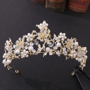 Close-up of golden bridal tiara with pearls, crystals, and floral rhinestone patterns
