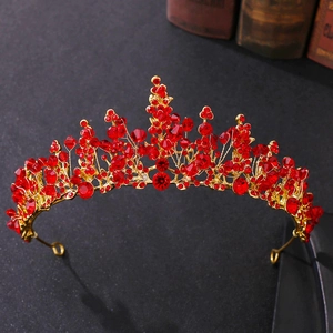 Close-up of handmade bridal crown with red crystals and intricate gold metal wirework