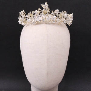 Close-up of golden bridal crown with floral crystals and handcrafted pearls on model