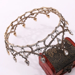 Detailed macro view of vintage gold crown with white rhinestones on a rustic red chest