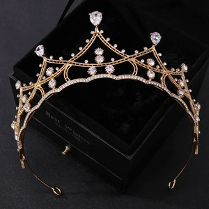 Gros plan d'un diadème doré de mariée avec cristaux sur un coffret cadeau noir
