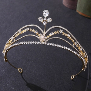 Detail of a golden floral bridal crown with intricate leaf patterns and sparkling rhinestones