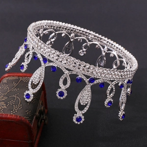 Detailed view of silver bridal crown with sparkling blue rhinestones on a dark background