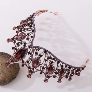 Detailed macro view of bronze baroque crown with red marquise stones and purple crystals