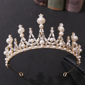 Detailed view of golden baroque crown featuring white pearls and shimmering clear crystals