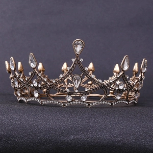 Detail of a vintage black Baroque bridal crown with clear crystals on a dark surface