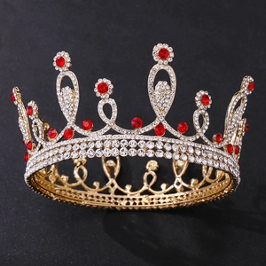 Detailed close-up of golden bridal crown with red ruby rhinestones and white crystals