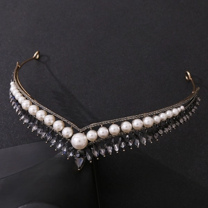 Detailed view of bridal crown with gold metal frame, white pearls, and smokey gemstones