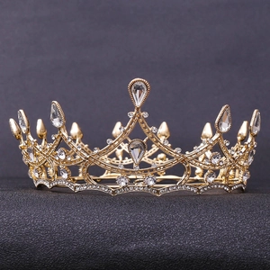Macro detail of Baroque gold bridal crown with luxury crystals and hollow metal patterns