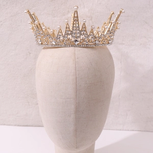 Baroque golden crown with sparkling crystals and white pearls on a mannequin display