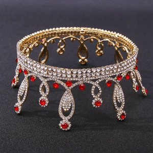 Close-up of golden bridal crown with white crystals and red pear-shaped rhinestones