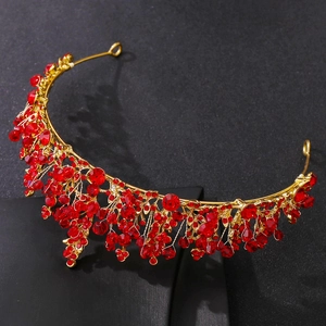 Macro shot of gold alloy bridal crown featuring red crystals and sparkling rhinestones