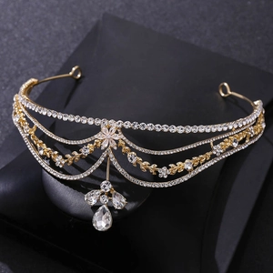 Detailed macro view of a gold floral tiara with rhinestones and a teardrop crystal