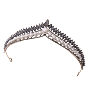 Close-up of golden V-shaped bridal tiara with white pearls and grey rhinestones