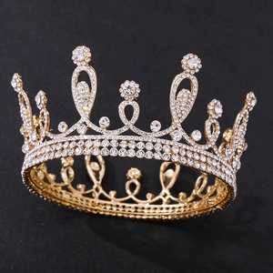 Close-up of golden bridal crown with intricate floral crystal patterns on black background