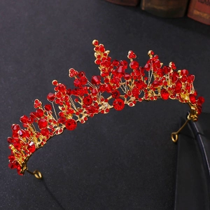 Macro detail of handmade red crystal tiara crown with gold beadwork on dark vintage base