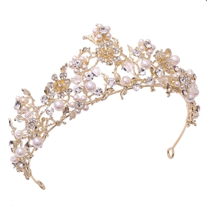 Detailed shot of golden bridal tiara featuring delicate pearls and crystal flower accents