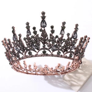 Close-up of Baroque crown with rose gold leaf frame and dark crystals on white background