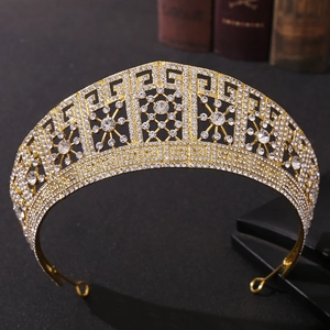 Macro shot of gold wedding crown with intricate openwork floral patterns and shiny rhinestones