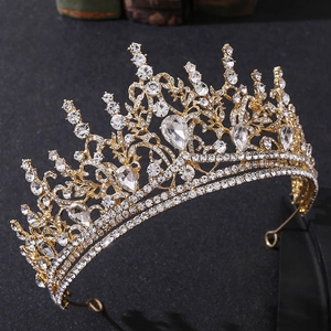 Macro view showing golden baroque tiara details with clear rhinestones and teardrop gems