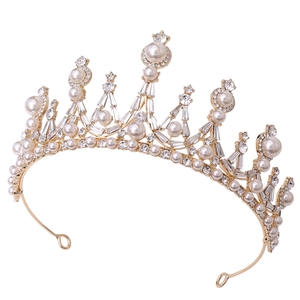 Close-up of golden baroque crown featuring white pearls and shimmering rhinestones