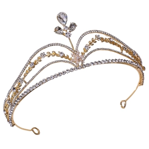 Close-up of golden crown tiara with intricate rhinestone flowers and waterdrop gems
