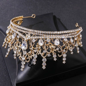 Close-up of golden baroque tiara with sparkling crystal teardrops and intricate scrolls