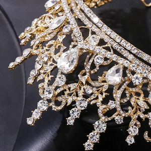 Close-up of baroque golden bridal crown featuring intricate teardrop rhinestones and carvings