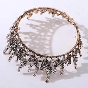Close-up detail of vintage gold tiara featuring rhinestone leaves and teardrop crystals