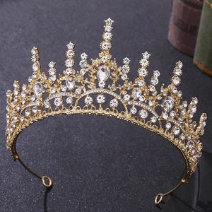 Gros plan sur une couronne baroque dorée avec strass blancs et cristaux en forme de larme