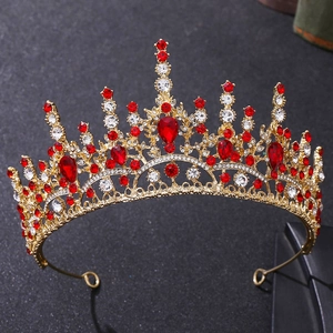 Détail d'une couronne dorée avec pierres rouges en goutte et cristaux blancs brillants