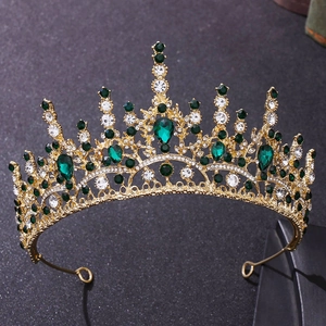 Détail macro de la couronne baroque dorée avec grandes émeraudes et cristaux blancs