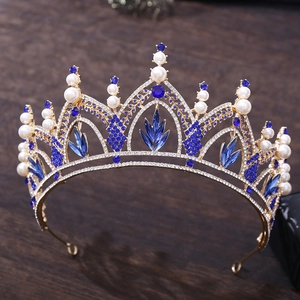 Détail de la couronne baroque dorée ornée de strass bleu foncé et de perles blanches