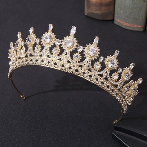 Detailed close-up of a gold bridal crown with shimmering zircons on a dark surface