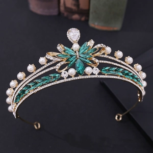 Detail view of gold bridal crown with emerald green stones and white pearls
