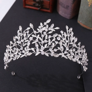 Detail view of silver leaf bridal tiara with sparkling crystals on black texture background
