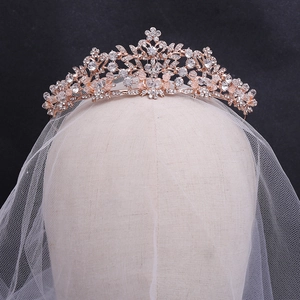 Detailed close-up of rose gold bridal tiara with rhinestones on a mannequin head