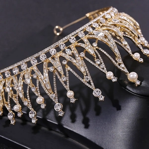 Détail macro d'une couronne de mariée dorée avec des cristaux et pampilles de perles