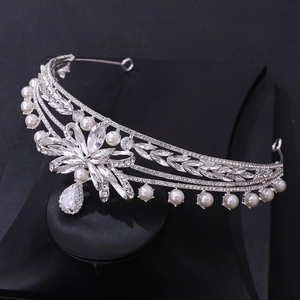 Detailed macro shot of silver bridal crown featuring teardrop crystal and white pearls