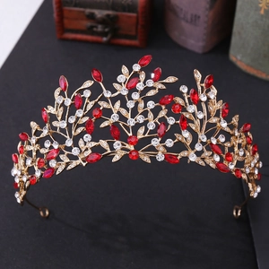 Detail of vintage bridal crown with red rhinestones and golden leaf branch design