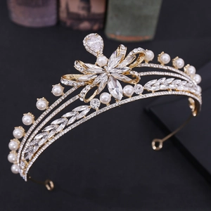 Macro side view of a golden bridal crown with sparkling zircons and white pearls
