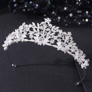 Silver bridal tiara with sparkling leaf patterns and rhinestones on a dark background