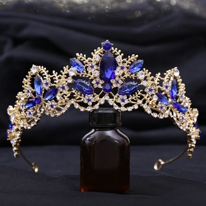 Macro shot of a gold vintage bridal crown featuring large navy blue gems and white crystals