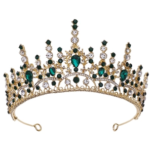 Détail de diadème baroque doré avec strass vert émeraude et filigrane ornemental